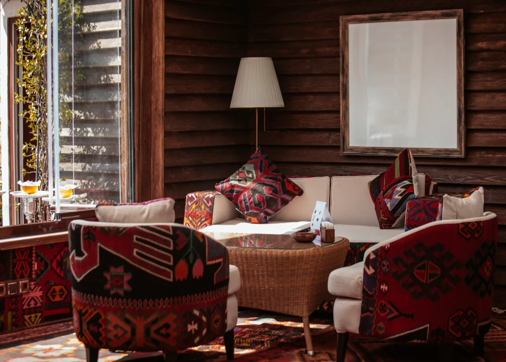 Small living-dining room, with African ethnic prints in reddish tones, wooden walls and natural textures